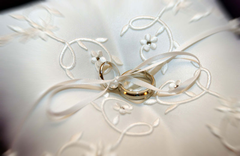 white ring bearer pillow with wedding rings