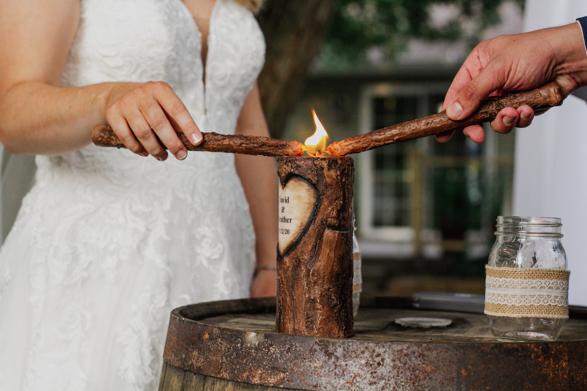 crop newlyweds lighting candle during ceremony