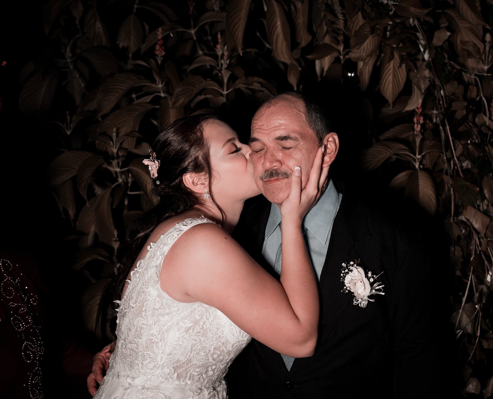 elegant bride kissing father on wedding day