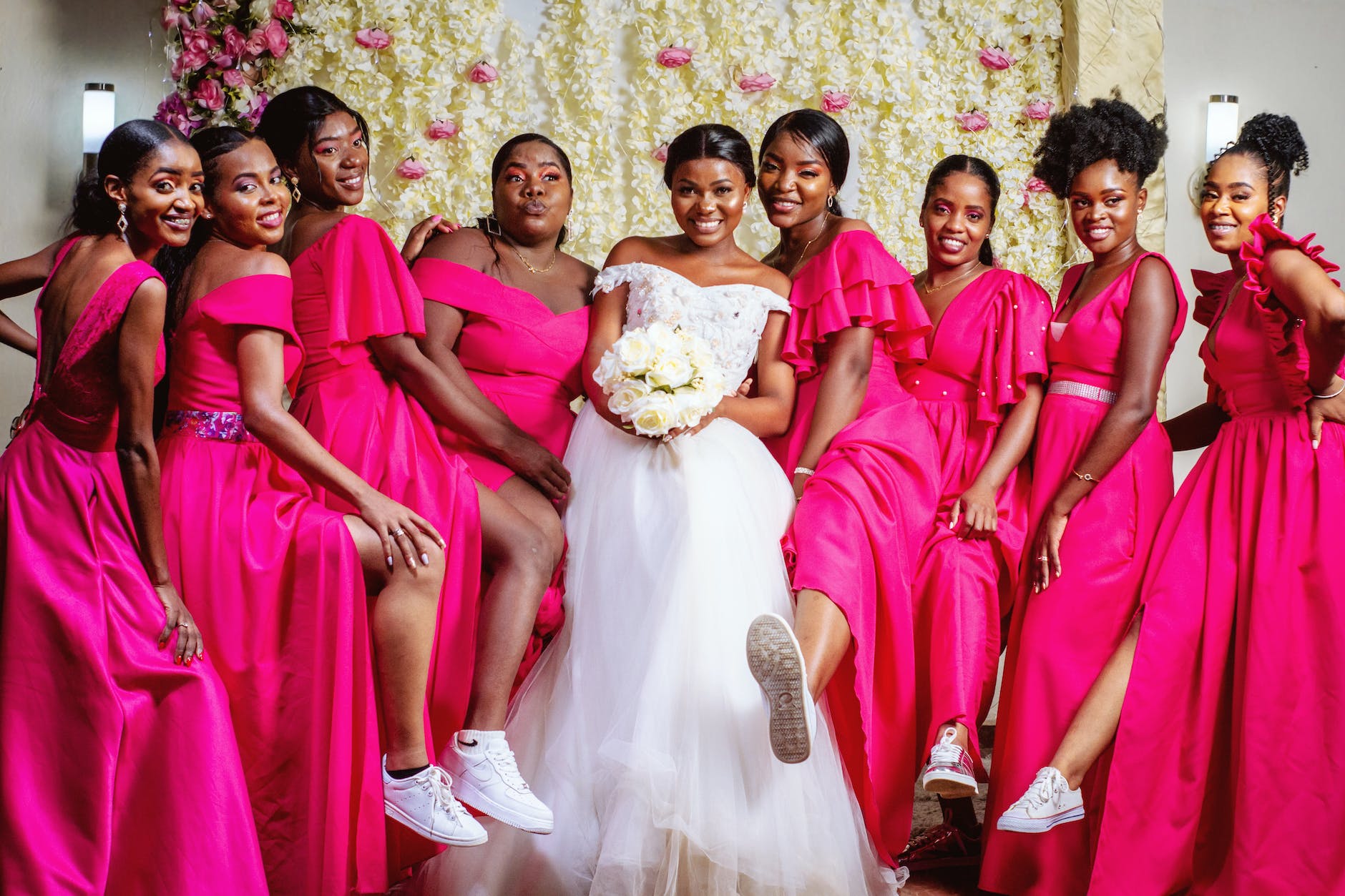 woman in bridal gown with women in pink dresses