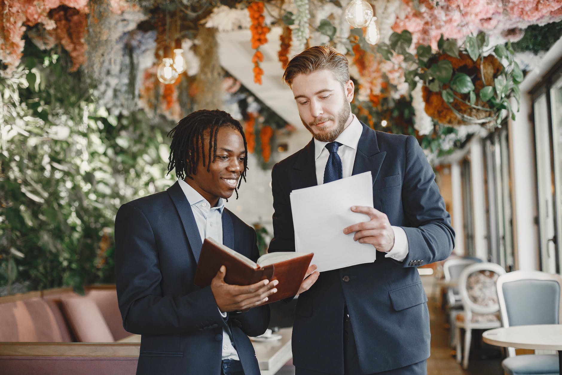 men in suits holding papers and notebooks in a wedding reception venue