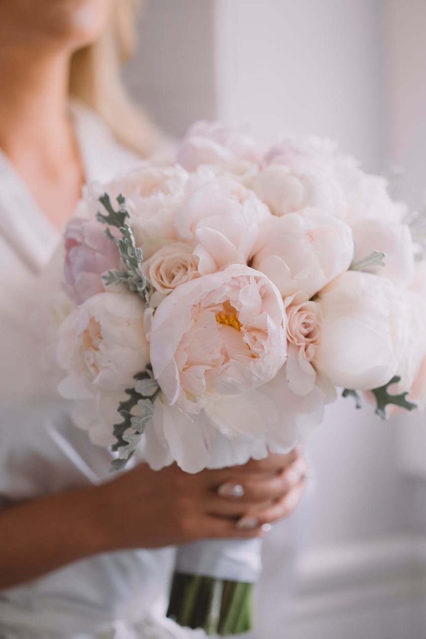 crop bride with blooming peony bouquet on wedding day