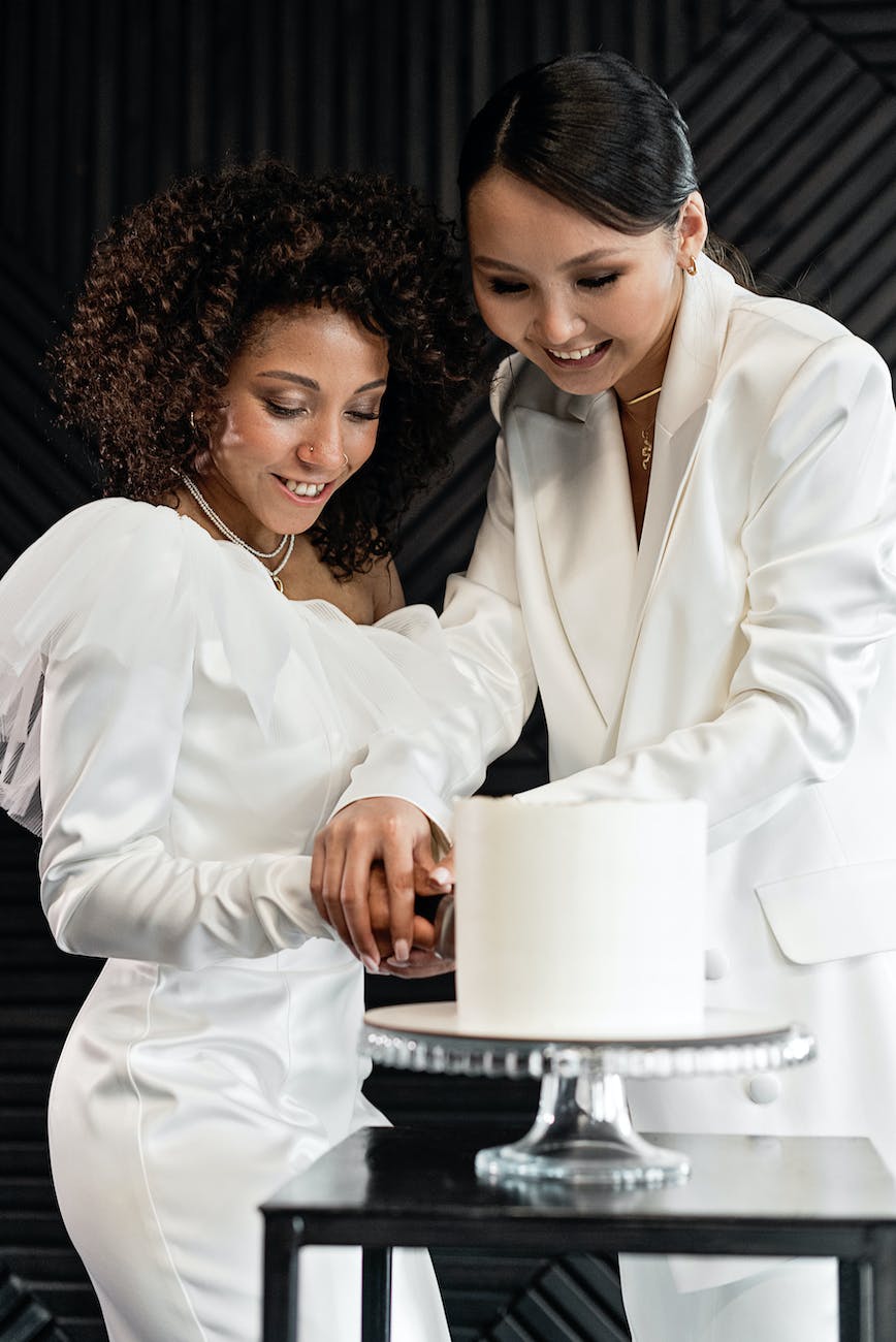 a happy newlywed couple cutting a wedding cake together