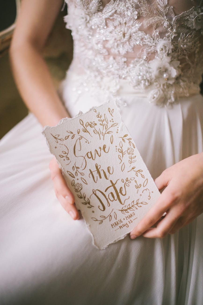 woman in white dress holding a wedding invitation