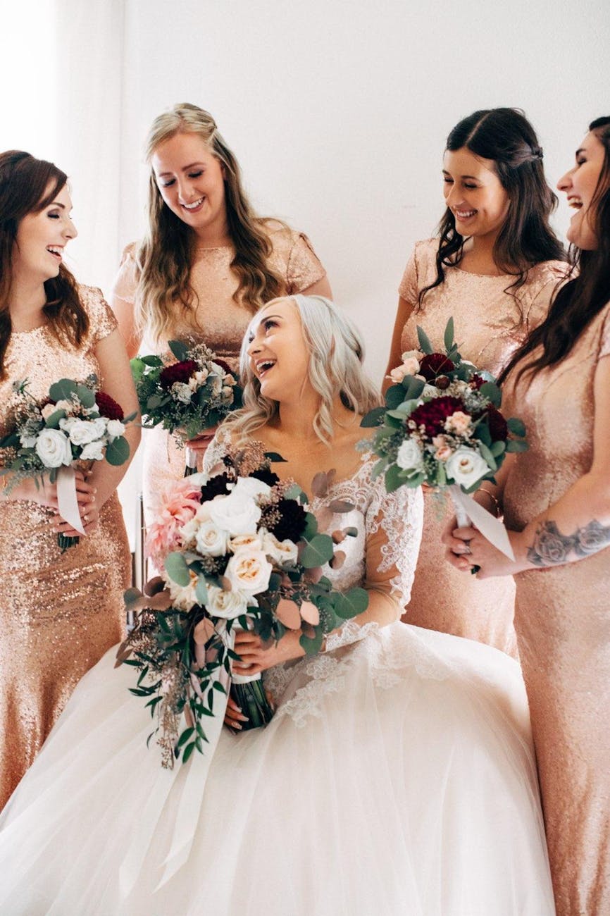 cheerful fiancee and bridesmaids with beautiful bouquets