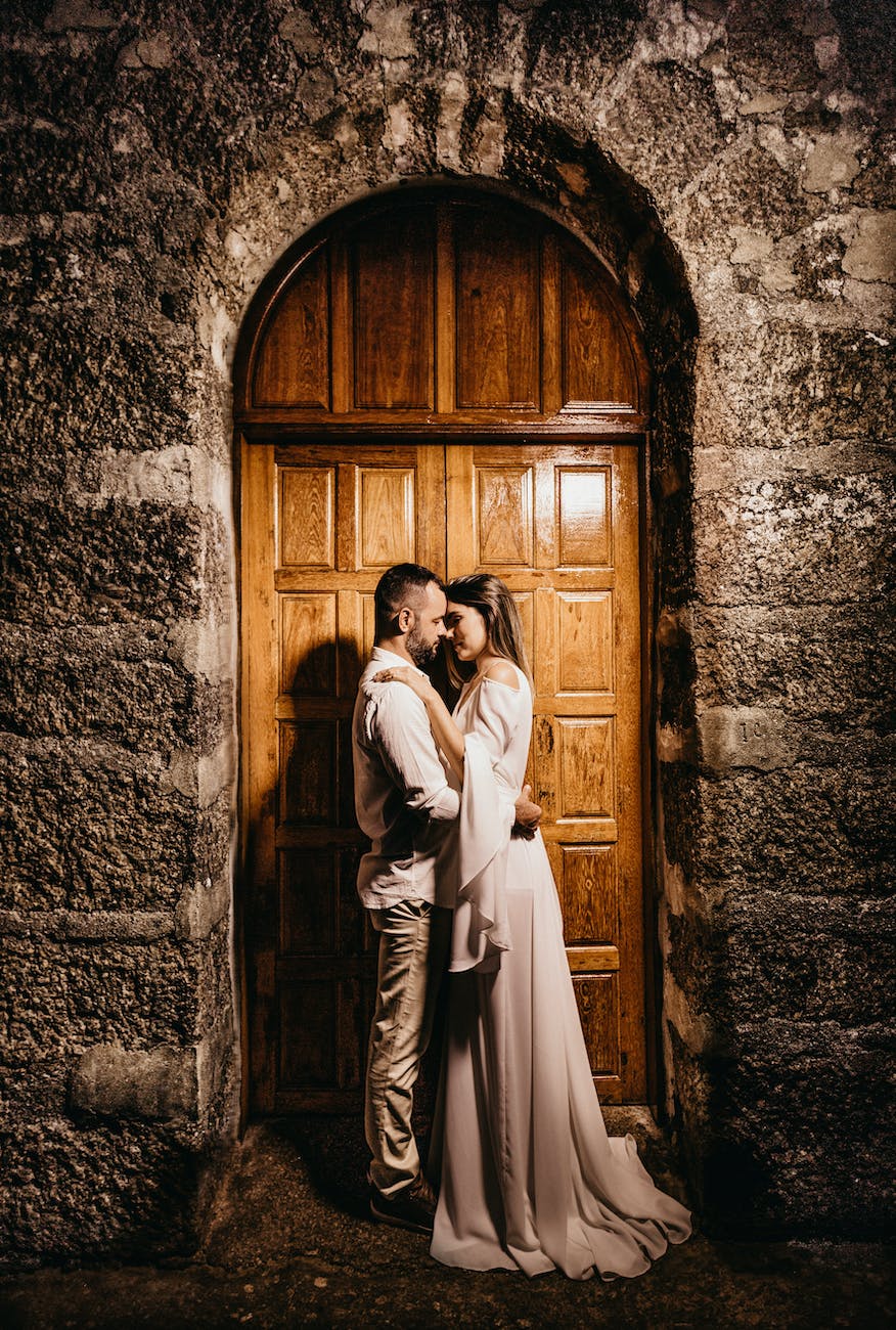 bride and groom kissing gesture in front of a wooden door