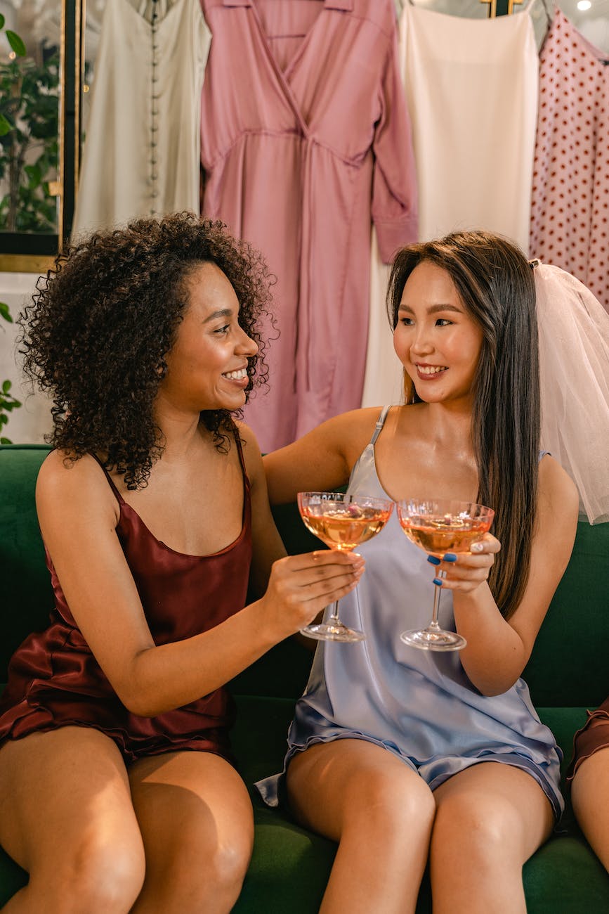 smiling women drinking cocktails at bridal party